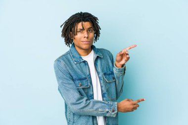 Kot ceket giyen genç siyah bir adam işaret parmağıyla fotokopi alanını işaret ederek şok oldu..