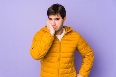 Mor arka planda izole edilmiş, üzgün ve dalgın hisseden, kopyalama alanına bakan genç adam..