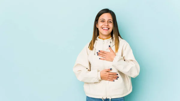 Jovem Mulher Isolada Fundo Azul Alegremente Diverte Mantendo Mãos Estômago — Fotografia de Stock