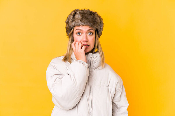 Young caucasian woman wearing a winter clothes isolated biting fingernails, nervous and very anxious.