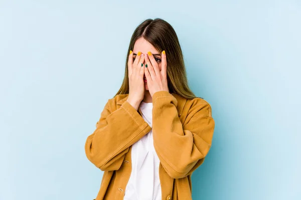 Jonge Blanke Vrouw Geïsoleerd Blauwe Achtergrond Knipperen Camera Door Vingers — Stockfoto