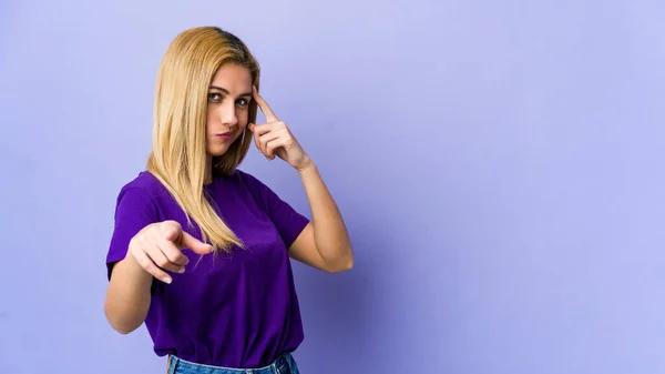 Mujer Rubia Joven Aislada Sobre Fondo Púrpura Apuntando Templo Con —  Fotos de Stock