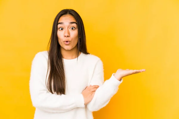 Mujer Joven Aislada Sobre Fondo Amarillo Impresionado Sosteniendo Espacio Copia — Foto de Stock