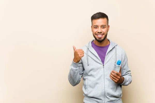 Νεαρός Ασιάτης Κρατώντας Ένα Μπουκάλι Νερό Χαμογελώντας Και Υψώνοντας Τον — Φωτογραφία Αρχείου