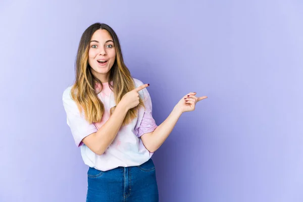 Joven Mujer Caucásica Aislada Sobre Fondo Púrpura Excitada Señalando Con —  Fotos de Stock