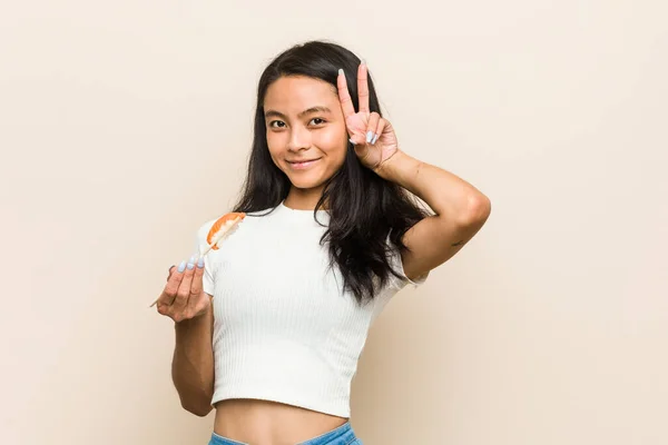 Joven Mujer Asiática Sosteniendo Una Pieza Sushi Mostrando Signo Victoria — Foto de Stock