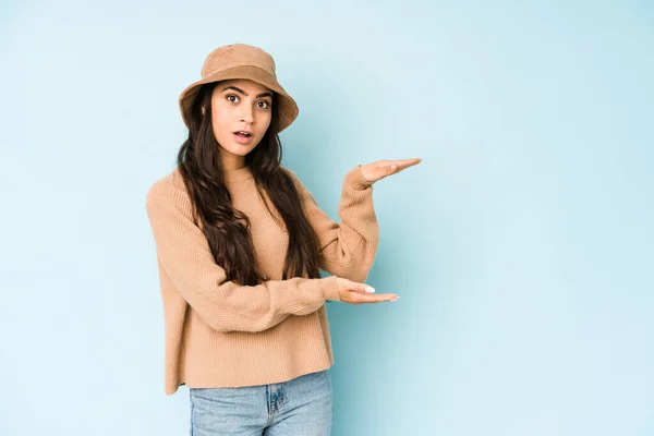 Mulher Indiana Jovem Usando Chapéu Isolado Fundo Azul Segurando Algo — Fotografia de Stock