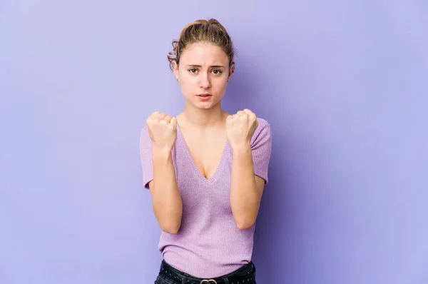 若いです白人女性紫の背景にカメラに拳を示す 積極的な顔の表情 — ストック写真