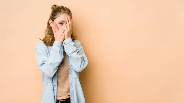 Jonge Blanke Vrouw Geïsoleerd Beige Achtergrond Knipperen Camera Door Vingers — Stockfoto