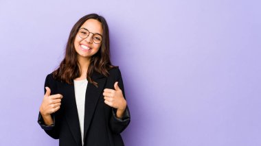 Genç, melez İspanyol kadın kendini izole edip gülümsüyor ve başparmağını kaldırıyor.