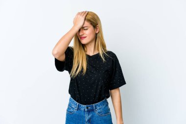 Beyaz arka planda izole edilmiş genç sarışın bir kadın bir şeyi unutuyor. Alnına avuç içi ile vuruyor ve gözlerini kapıyor..