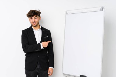 Genç iş adamı Arap adama koçluk yapıyor gülümsüyor ve boş alanda bir şeyler gösteriyor..