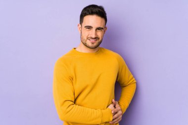 Mor arka planda karaciğer ağrısı çeken, karnı ağrıyan genç beyaz bir adam..