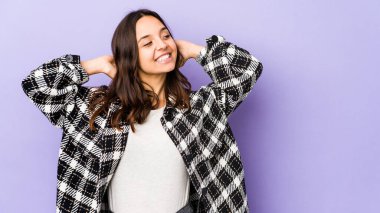 Genç, melez İspanyol kadın kendini soyutlamış, kendinden emin, elleri başının arkasında..