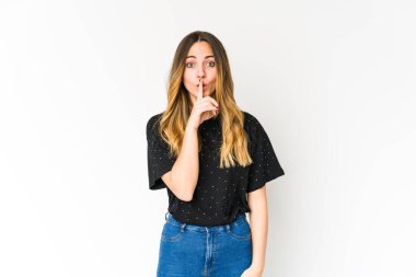 Beyaz arka planda izole edilmiş genç beyaz kadın ya sır saklıyor ya da sessizlik istiyor..