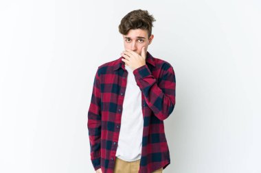 Beyaz arka planda izole edilmiş genç beyaz bir adam ağzı kapalı ve elleri endişeli görünüyor..