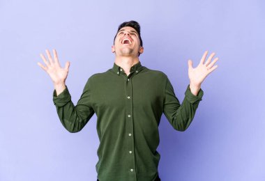 Mor arka planda izole edilmiş genç beyaz adam gökyüzüne haykırıyor, yukarı bakıyor, hayal kırıklığına uğramış..