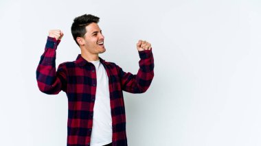 Beyaz arka planda izole edilmiş genç beyaz bir adam zaferden sonra yumruğunu kaldırıyor, kazanan konsept.