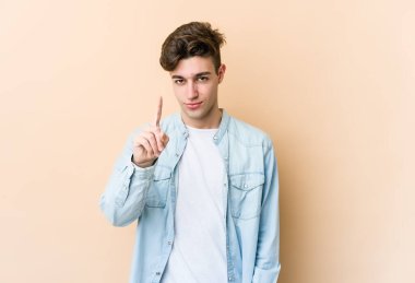 Beyazlı genç bir adam bej arka planda izole edilmiş. Parmak izi 1 numara..