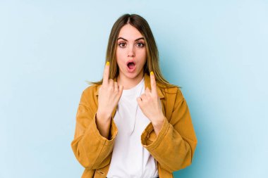 Mavi arka planda izole edilmiş beyaz bir kadın ağzı açık bir şekilde üst tarafı işaret ediyor..