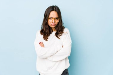 Latin kökenli genç bir kadın hoşnutsuzca kaşlarını çatmış, kollarını kavuşturmuş..