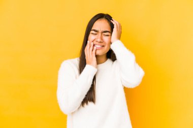 Sarı arka planda yalnız kalmış genç bir kadın sızlanıyor ve ağlıyordu..