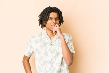 Genç Afrikalı Amerikalı Rasta adam şüpheli ve şüpheci bir ifadeyle yana bakıyor..