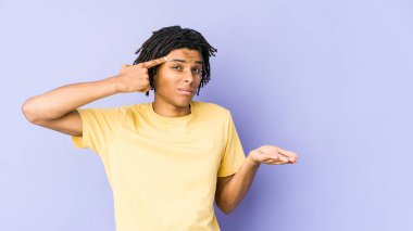 Genç Afro-Amerikan Rasta Adam elinde bir ürünü tutuyor ve gösteriyor..