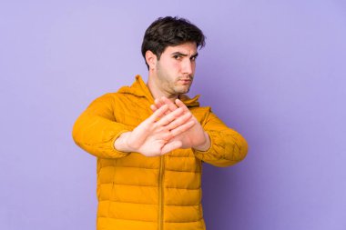 Mor arka planda izole edilmiş genç bir adam elini uzatmış, dur işareti gösteriyor, bu da seni engelliyor..