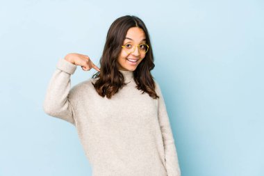 Genç, Latin kökenli bir kadın tişört fotokopi alanını elle işaret ediyor, gururlu ve kendinden emin.