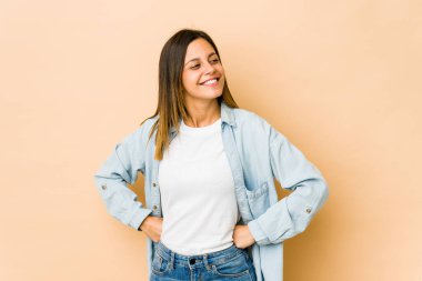 Bej arka planda izole edilmiş genç bir kadın hedeflere ve amaçlara ulaşma hayali kuruyor.