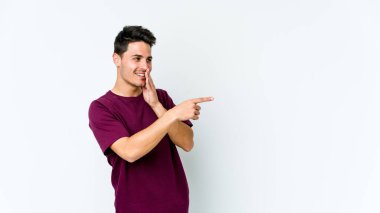 Beyaz arka planda izole edilmiş genç beyaz bir adam bir dedikodu söylüyor, bir haber sunuyor..