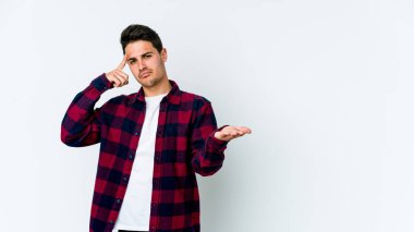 Beyaz arka planda izole edilmiş genç beyaz bir adam elinde bir ürün tutuyor ve.