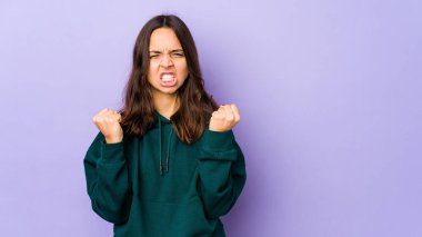 Genç, melez İspanyol kadın kameraya yumruk gösteriyor, agresif bir yüz ifadesi var..
