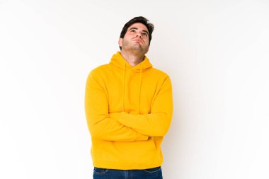 Beyaz arka planda izole edilmiş genç adam tekrarlanan bir görevden yoruldu..