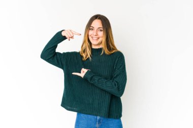 Beyaz arka planda izole edilmiş genç beyaz bir kadın. Elinde parmakları olan, gülümseyen ve kendinden emin bir şey tutuyor..