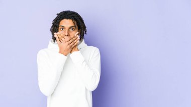 Genç Afrikalı Amerikalı Rasta adam elleriyle ağzını kapatırken şok oldu..