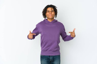 Afro-Amerikan Rasta 'lı genç bir adam gömleğin fotokopi odasını elle gösteriyor, gururlu ve kendinden emin.