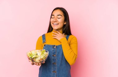 Salata tutan Asyalı genç bir kadın yalnızken kahkahalar atıyor..