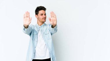 Beyaz arka planda izole edilmiş genç beyaz bir adam elini uzatmış, dur işareti göstererek seni engelliyor..