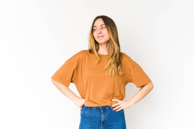 Beyaz arka planda izole edilmiş genç beyaz kadın hedeflere ve amaçlara ulaşmayı hayal ediyor.