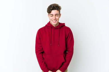 Beyaz arka planda izole edilmiş genç beyaz adam gülüyor ve gözlerini kapıyor, rahatlamış ve mutlu hissediyor..