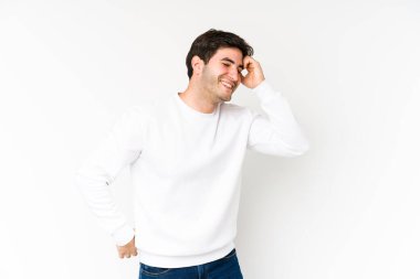 Genç adam beyaz arka planda neşeli bir şekilde gülüyor. Mutluluk kavramı.