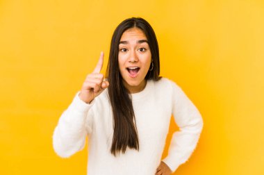 Sarı arka planda izole edilmiş genç bir kadının bir fikri, ilham konsepti var..