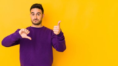Kafkasyalı genç adam sarı fırında izole edilmiş, baş parmağını kaldırmıyor, zor seçim konsepti.