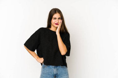 Beyaz arka planda izole edilmiş beyaz tenli genç bir kadın üzgün ve dalgın bir şekilde fotokopi odasına bakıyor..