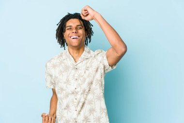 Genç Afro-Amerikan Rasta adamı gamsız ve heyecanlı bir şekilde tezahürat yapıyor. Zafer konsepti.