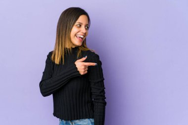 Mor arka planda soyutlanmış genç bir kadın. Gülümsüyor, neşeli ve keyifli görünüyor..