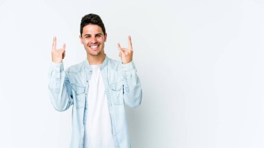 Beyaz arka planda izole edilmiş genç beyaz bir adam boynuzlarını devrim konsepti olarak gösteriyor..