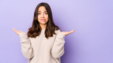 Latin kökenli genç bir kadın. Kafası karışmış ve omuz silkiyor. Kopya alanını tutmak için..